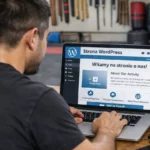 Osoba trenująca filipińskie sztuki walki pracuje przy laptopie w sali treningowej, tworząc stronę WordPress.