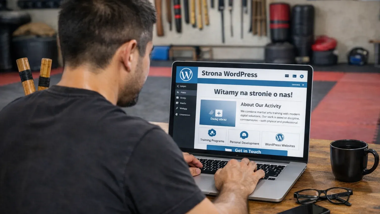 Osoba trenująca filipińskie sztuki walki pracuje przy laptopie w sali treningowej, tworząc stronę WordPress.